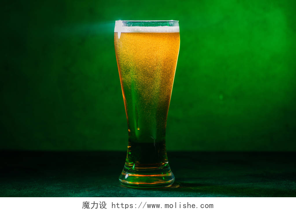 绿色背景下的啤酒玻璃杯绿色新冷琥珀啤酒玻璃特写图